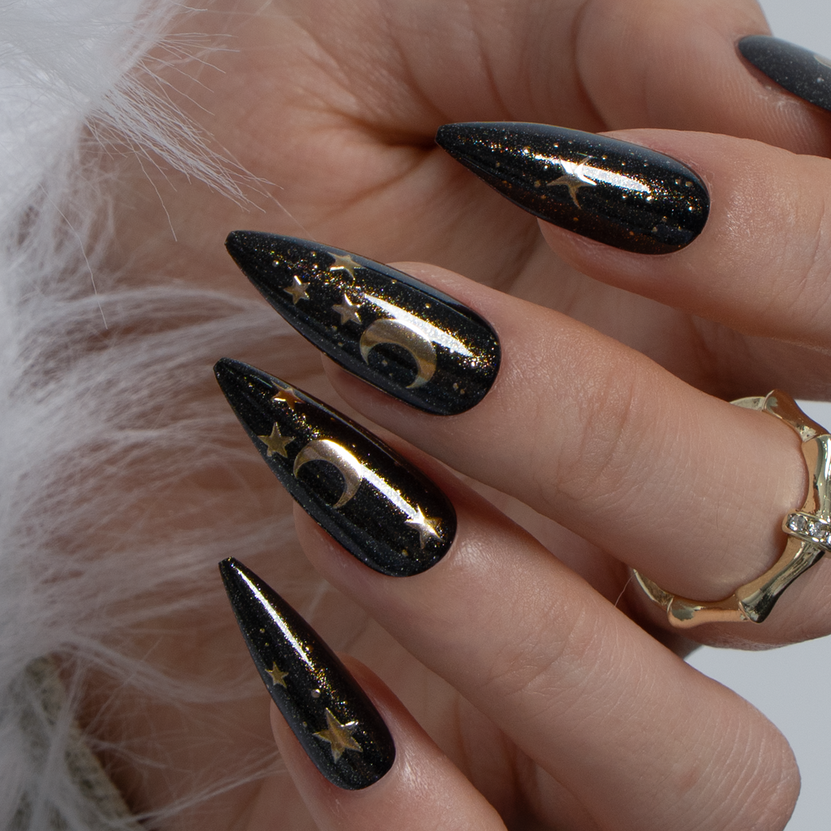 Lunar Charm Press-On Nails – long stiletto shape with black glitter base, gold moon crescents and star charms